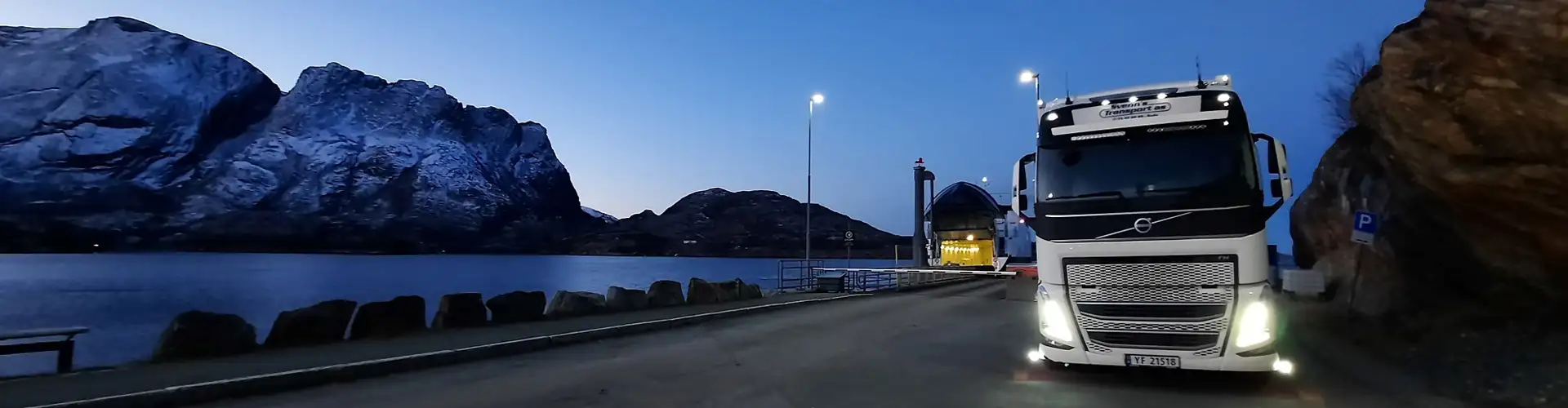 Foto av kjøretøy fra Svenns Transport som står parkert ved et fergeleie